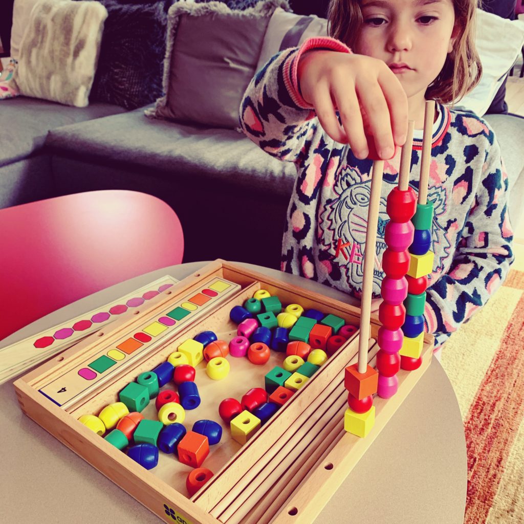 enfant jouant avec un jeu éducatif en bois