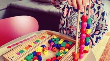 enfant jouant avec un jeu éducatif en bois